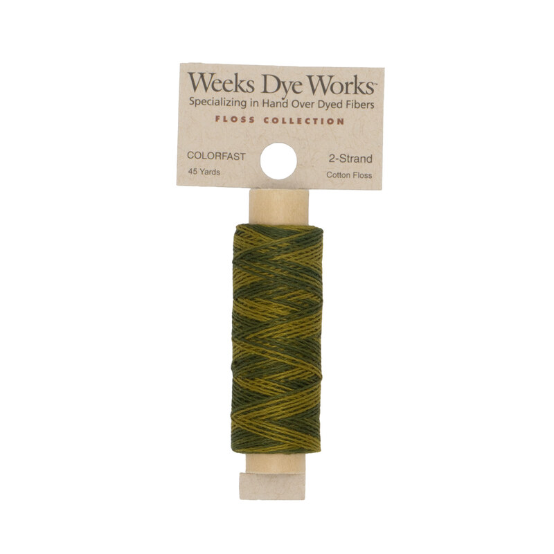 A spool of olive green embroidery floss with a tan label featuring the brand name and color information.