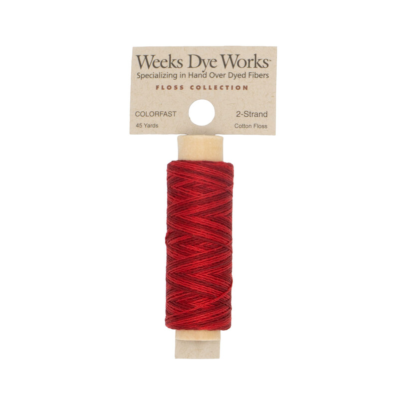 A spool of cardinal red embroidery floss with a tan label featuring the brand name and color information.
