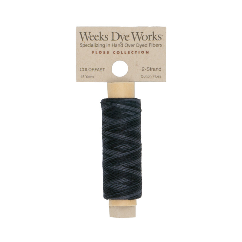 A spool of soft black embroidery floss with a tan label featuring the brand name and color information.