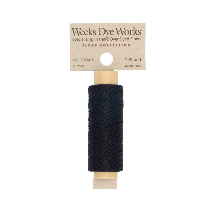 A spool of black embroidery floss with a tan label featuring the brand name and color information.