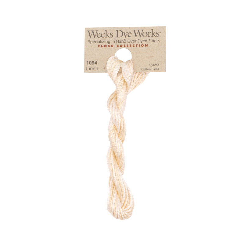 A skein of warm ecru embroidery floss, twisted and bundled, with a tan label featuring the brand name and color information.