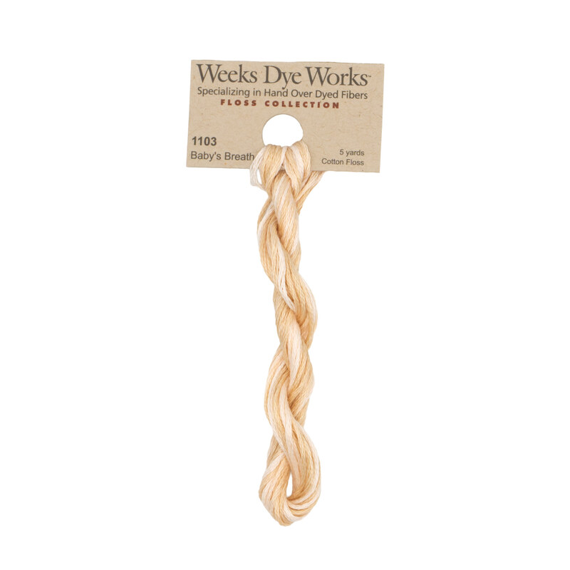 A skein of peach and cream embroidery floss, twisted and bundled, with a tan label featuring the brand name and color information.