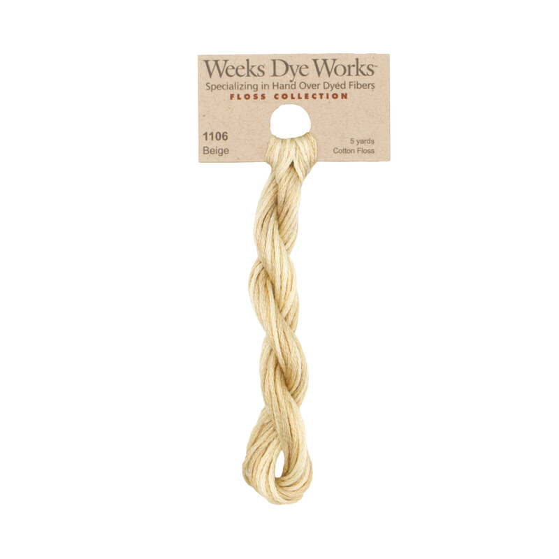 A skein of pale beige embroidery floss, twisted and bundled, with a tan label featuring the brand name and color information.