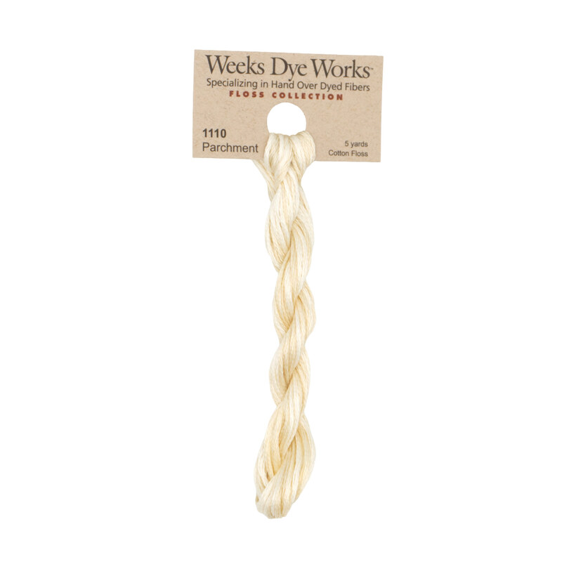 A skein of cream embroidery floss, twisted and bundled, with a tan label featuring the brand name and color information.