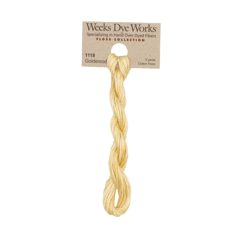 A skein of straw embroidery floss, twisted and bundled, with a tan label featuring the brand name and color information.