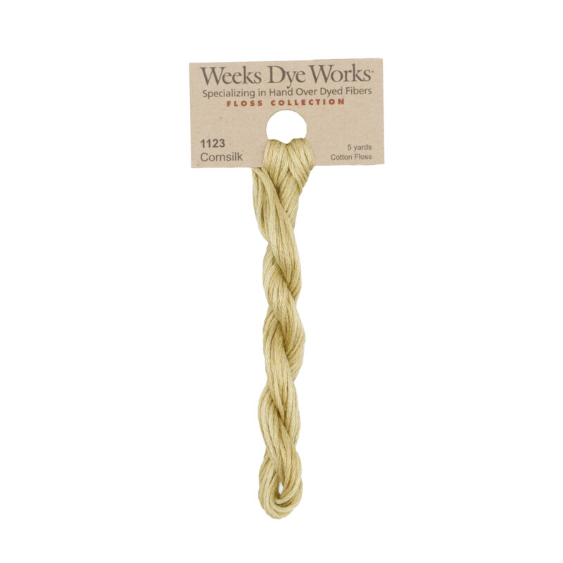 A skein of light beige embroidery floss, twisted and bundled, with a tan label featuring the brand name and color information.