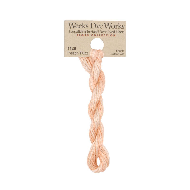A skein of Variegated Peach and Cream embroidery floss, twisted and bundled, with a tan label featuring the brand name and color information.