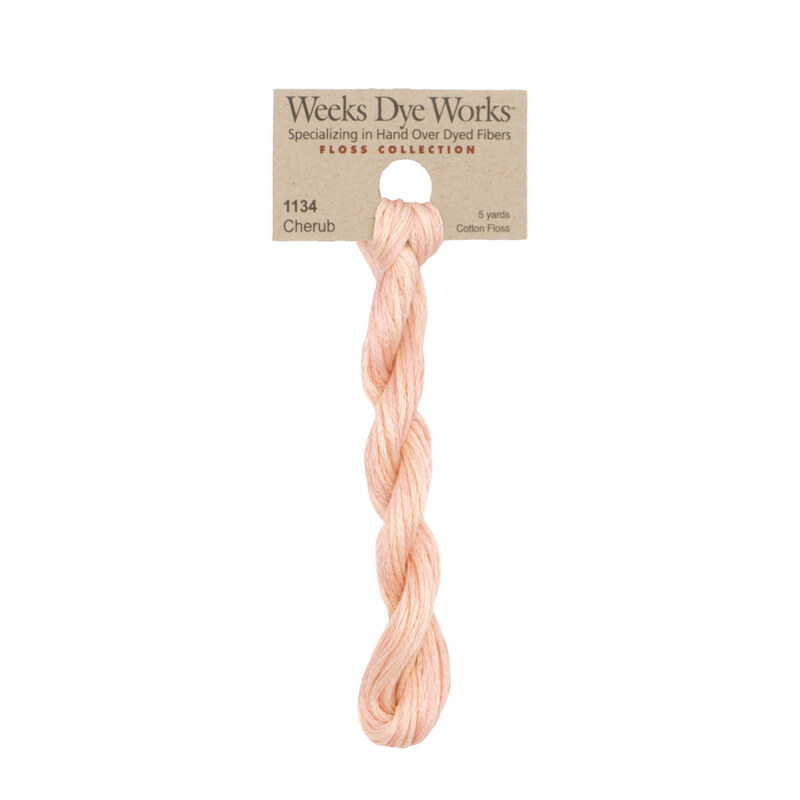 A skein of Pastel Pink embroidery floss, twisted and bundled, with a tan label featuring the brand name and color information.