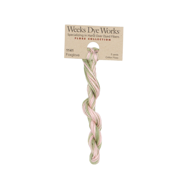 A skein of Variegated Light Pink and Sage Green embroidery floss, twisted and bundled, with a tan label featuring the brand name and color information.