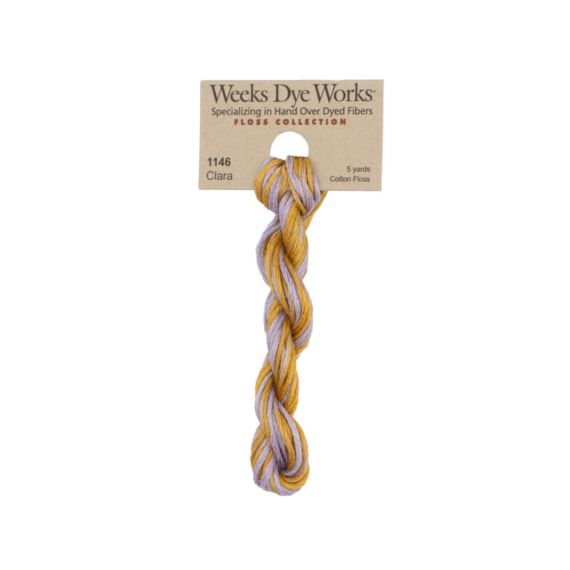 A skein of Variegated Gold and Heather embroidery floss, twisted and bundled, with a tan label featuring the brand name and color information.