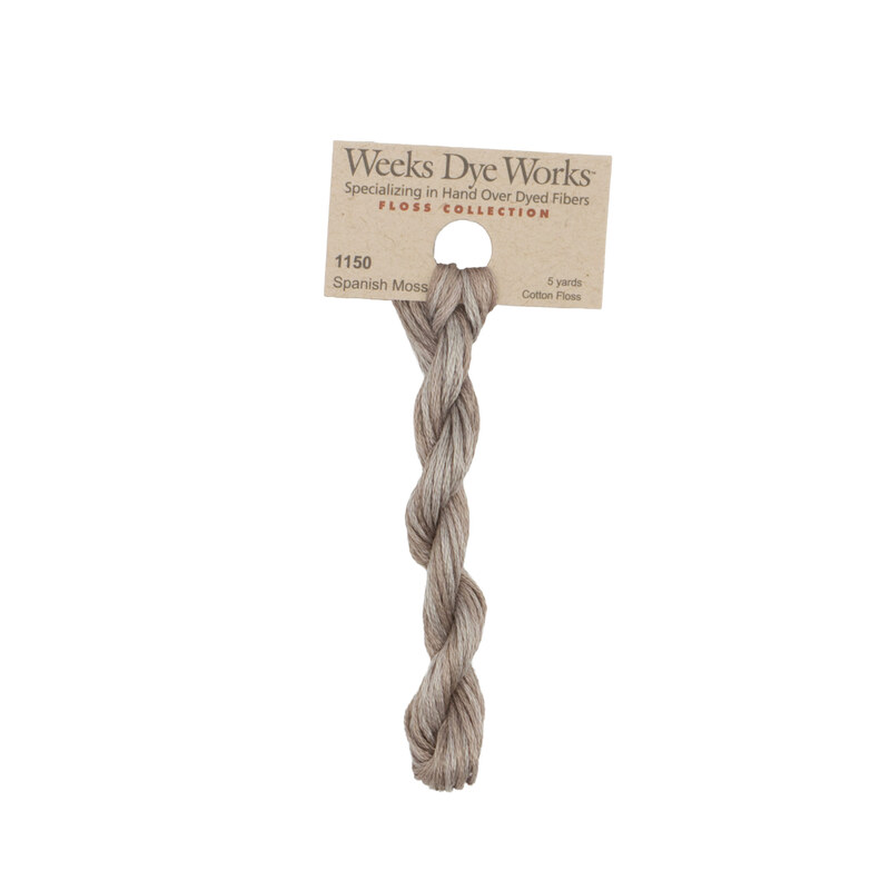 A skein of ash gray embroidery floss, twisted and bundled, with a tan label featuring the brand name and color information.