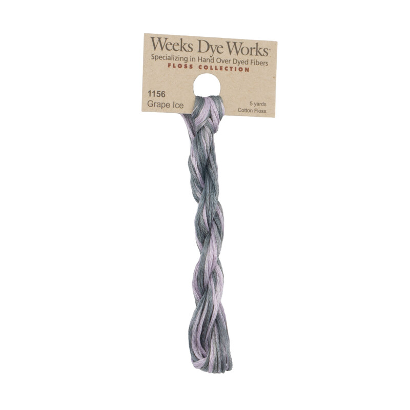 A skein of thistle purple and pink beige embroidery floss, twisted and bundled, with a tan label featuring the brand name and color information.