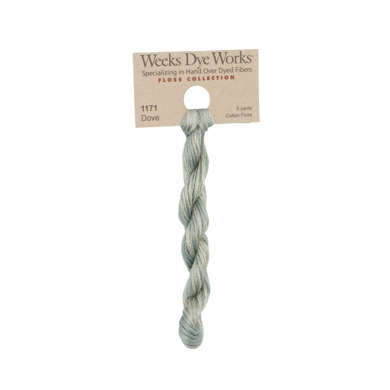 A skein of bluish gray embroidery floss, twisted and bundled, with a tan label featuring the brand name and color information.