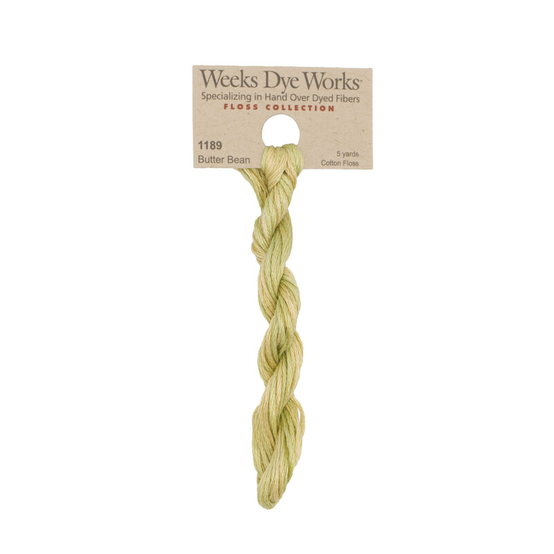 A skein of lemongrass embroidery floss, twisted and bundled, with a tan label featuring the brand name and color information.