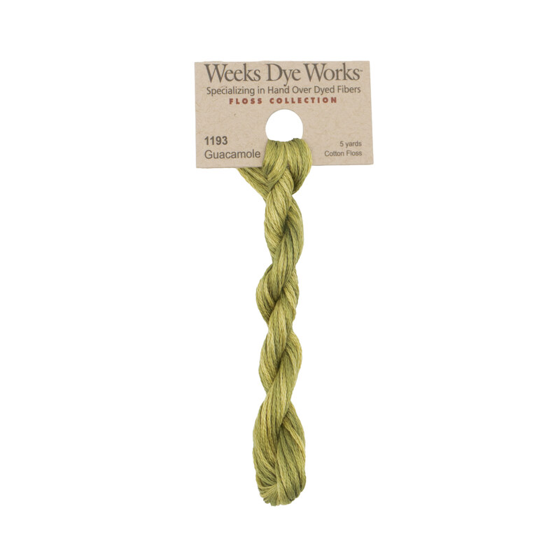 A skein of light green embroidery floss, twisted and bundled, with a tan label featuring the brand name and color information.