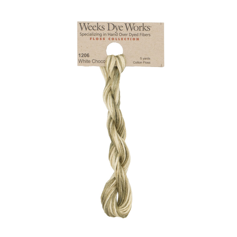 A skein of cream and brown embroidery floss, twisted and bundled, with a tan label featuring the brand name and color information.
