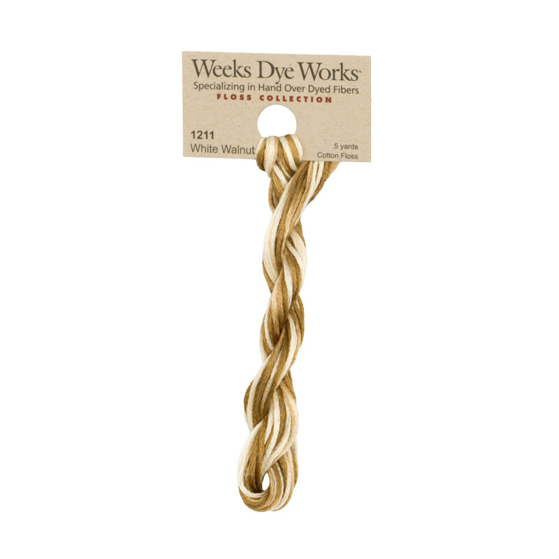 A skein of white and nut brown embroidery floss, twisted and bundled, with a tan label featuring the brand name and color information.
