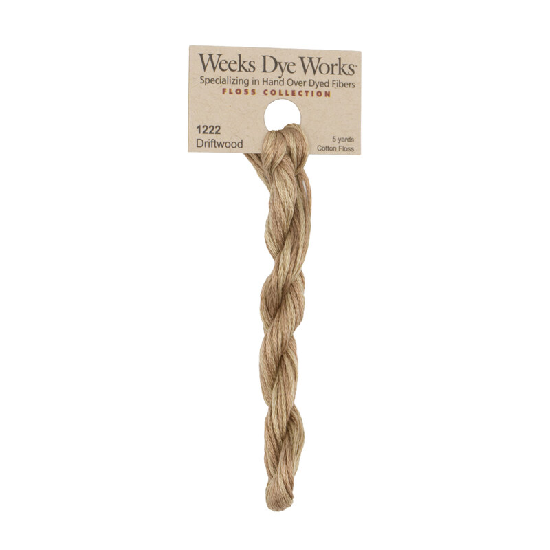 A skein of sand tan embroidery floss, twisted and bundled, with a tan label featuring the brand name and color information.