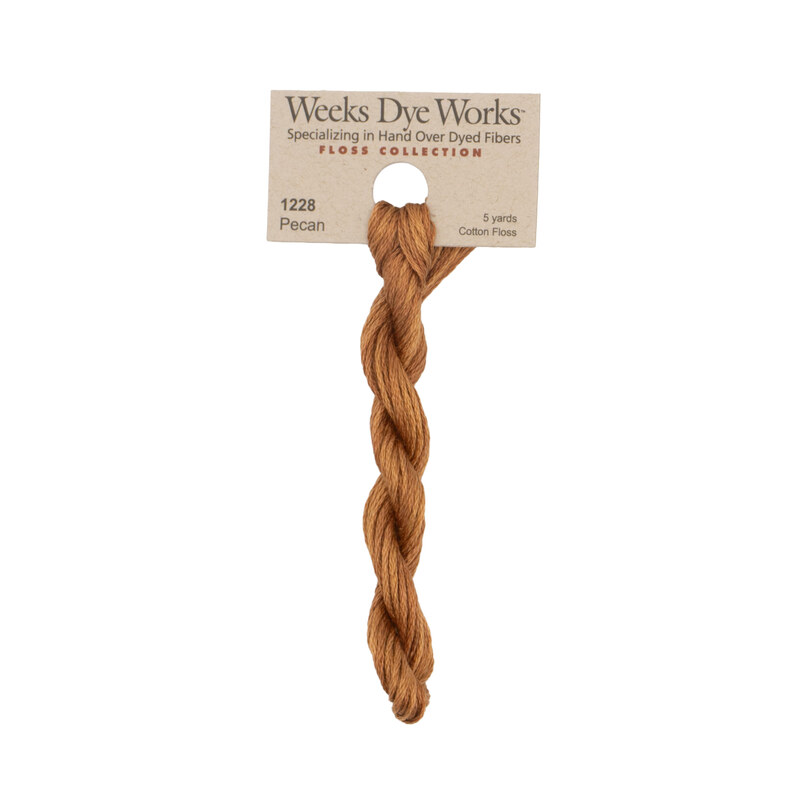 A skein of ginger embroidery floss, twisted and bundled, with a tan label featuring the brand name and color information.