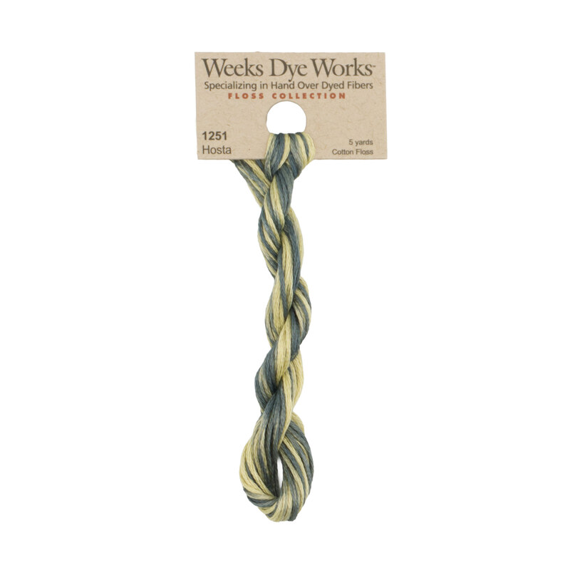 A skein of variegated thyme and light pear embroidery floss, twisted and bundled, with a tan label featuring the brand name and color information.