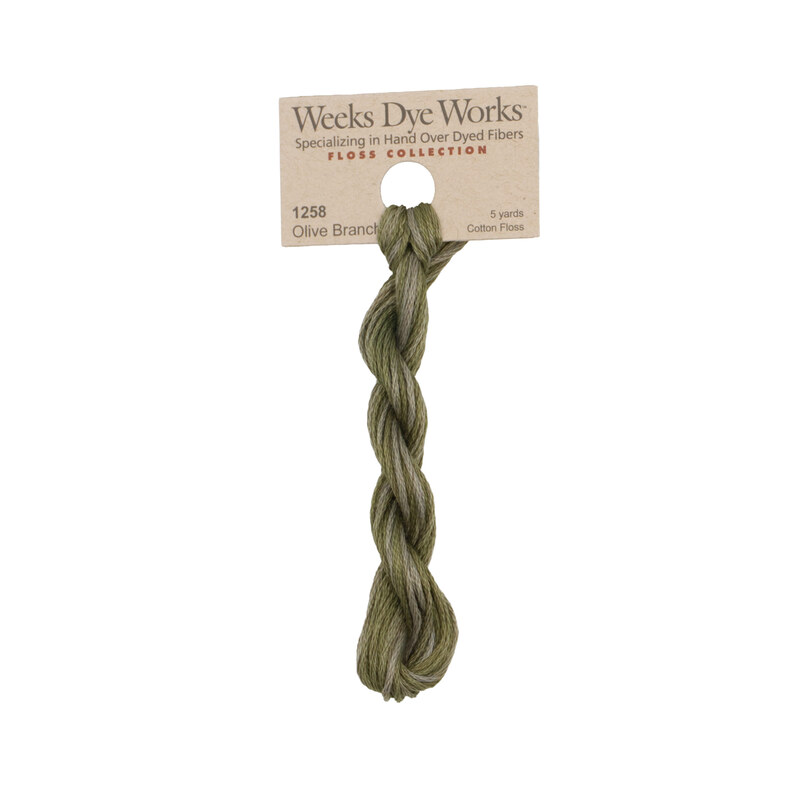 A skein of dark olive green embroidery floss, twisted and bundled, with a tan label featuring the brand name and color information.
