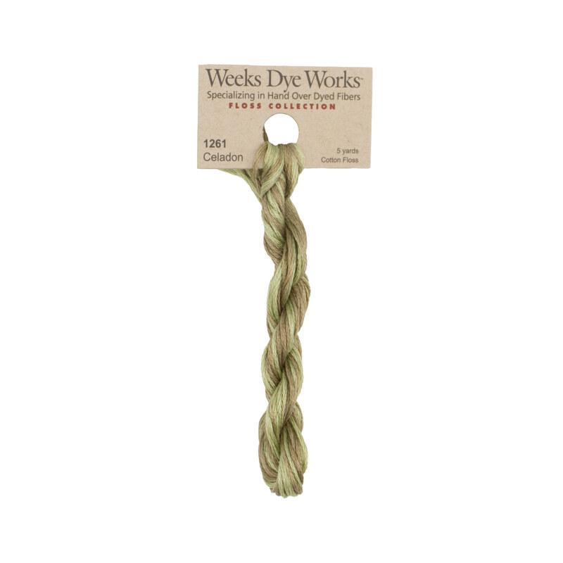 A skein of sage green and khaki embroidery floss, twisted and bundled, with a tan label featuring the brand name and color information.