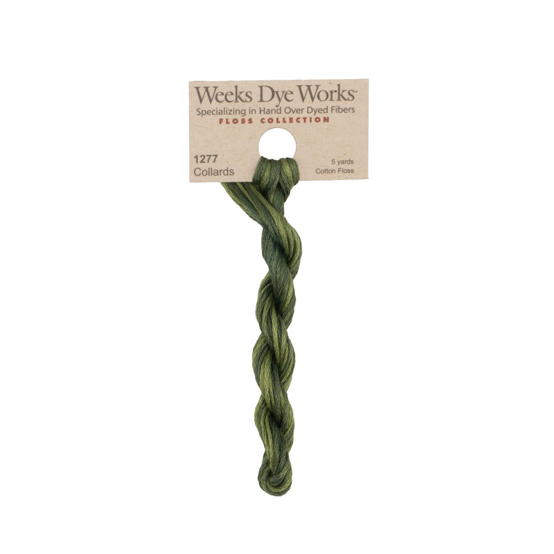 A skein of green embroidery floss, twisted and bundled, with a tan label featuring the brand name and color information.