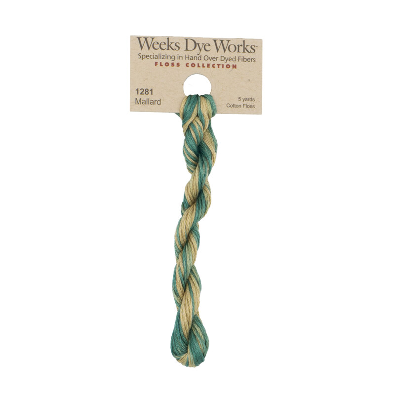 A skein of variegated light green and flax embroidery floss, twisted and bundled, with a tan label featuring the brand name and color information.