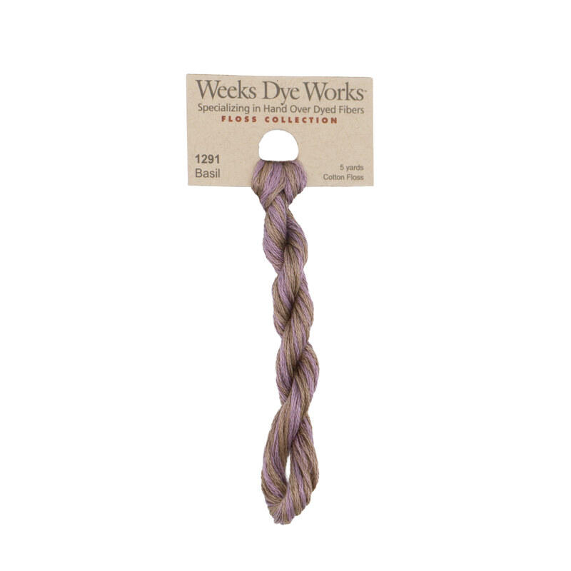 A skein of variegated lilac and tan embroidery floss, twisted and bundled, with a tan label featuring the brand name and color information.