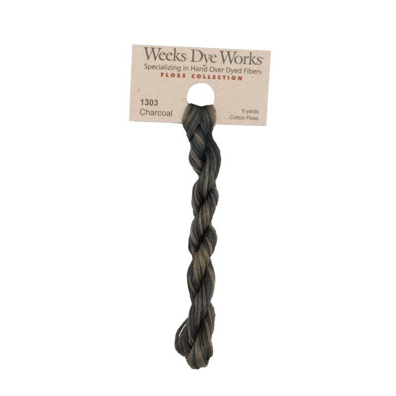 A skein of dark warm gray embroidery floss, twisted and bundled, with a tan label featuring the brand name and color information.