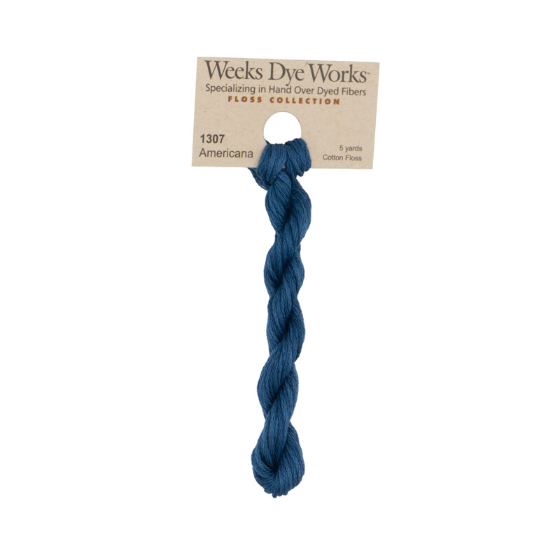 A skein of patriotic blue embroidery floss, twisted and bundled, with a tan label featuring the brand name and color information.