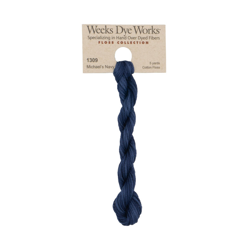 A skein of navy blue embroidery floss, twisted and bundled, with a tan label featuring the brand name and color information.?