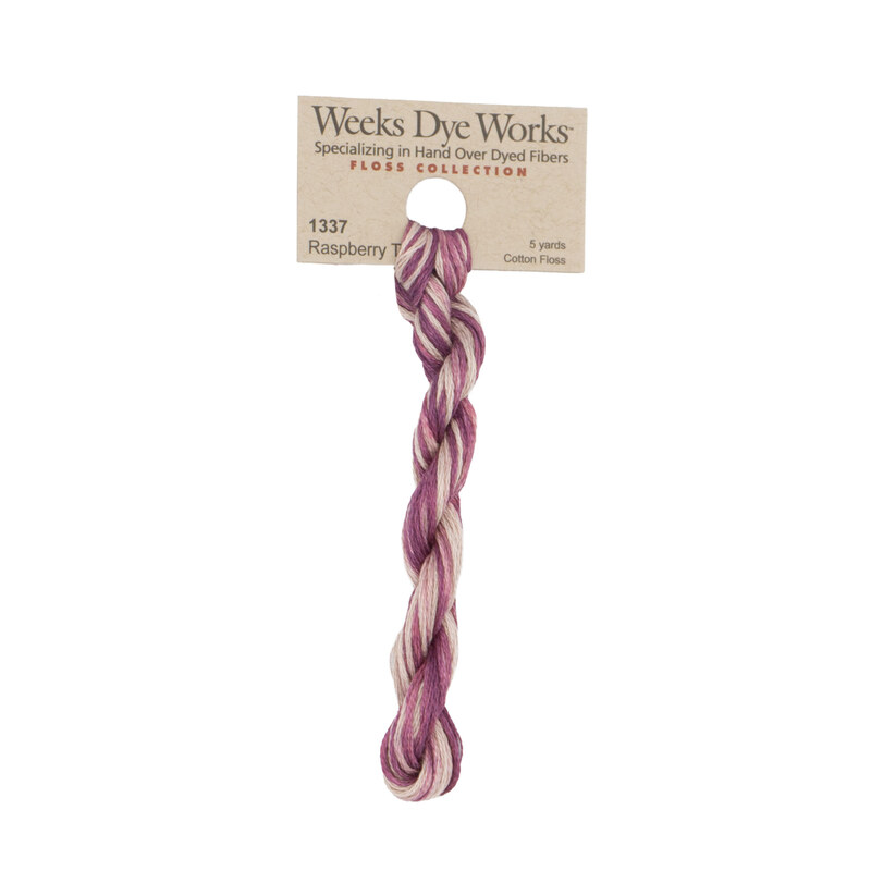 A skein of variegated magenta and light pink embroidery floss, twisted and bundled, with a tan label featuring the brand name and color information.