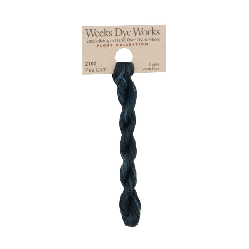 A skein of teal black embroidery floss, twisted and bundled, with a tan label featuring the brand name and color information.