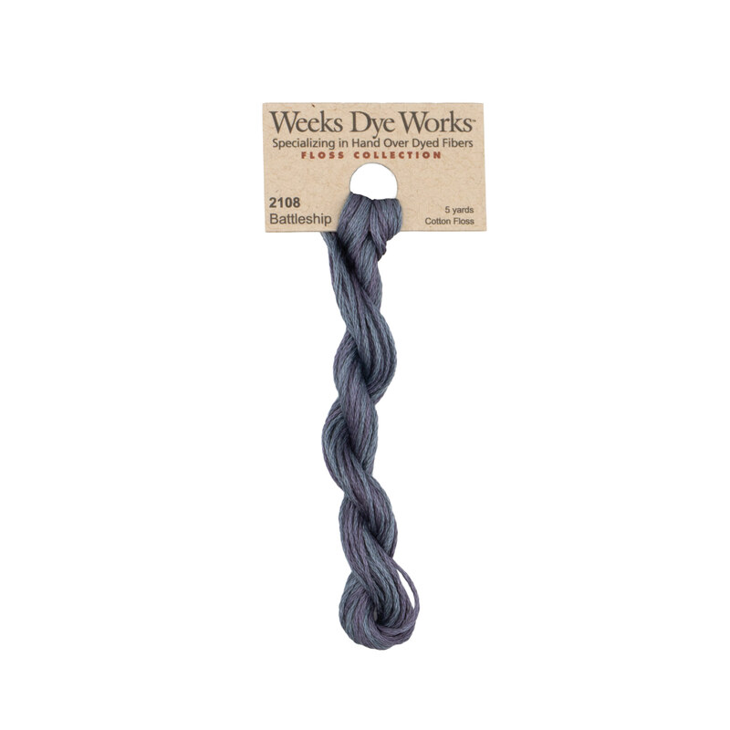 A skein of variegated cadet blue and violet embroidery floss, twisted and bundled, with a tan label featuring the brand name and color information.