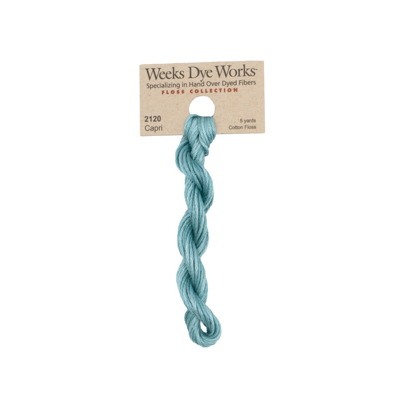 A skein of medium turquoise embroidery floss, twisted and bundled, with a tan label featuring the brand name and color information.