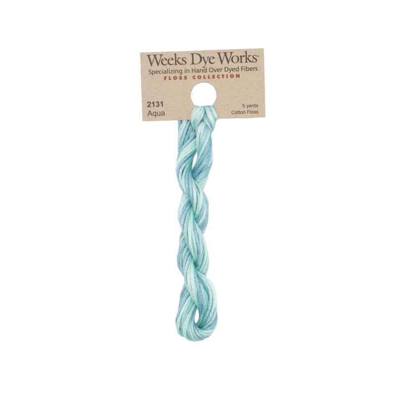 A skein of variegated aquamarine embroidery floss, twisted and bundled, with a tan label featuring the brand name and color information.