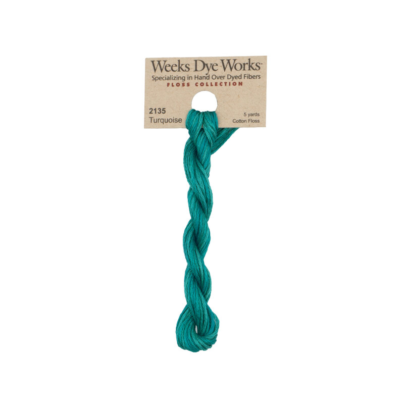 A skein of teal embroidery floss, twisted and bundled, with a tan label featuring the brand name and color information.