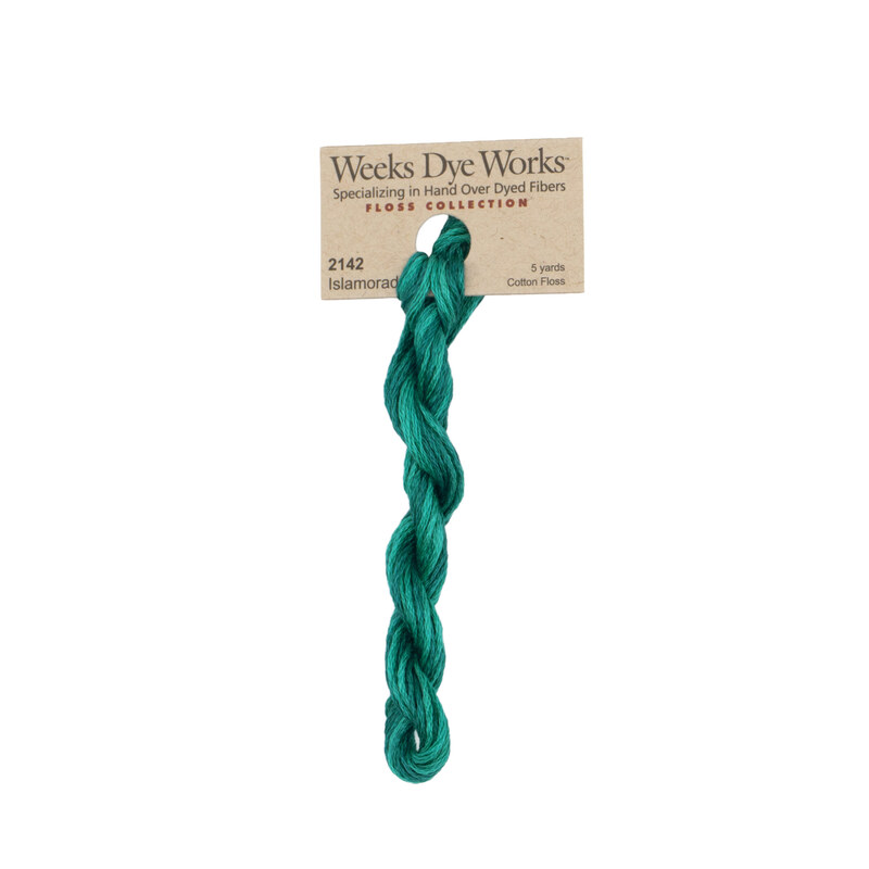 A skein of bright viridian embroidery floss, twisted and bundled, with a tan label featuring the brand name and color information.