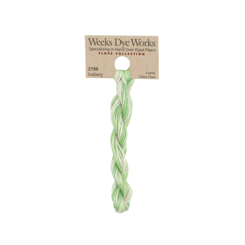 A skein of variegated mint and off white embroidery floss, twisted and bundled, with a tan label featuring the brand name and color information.