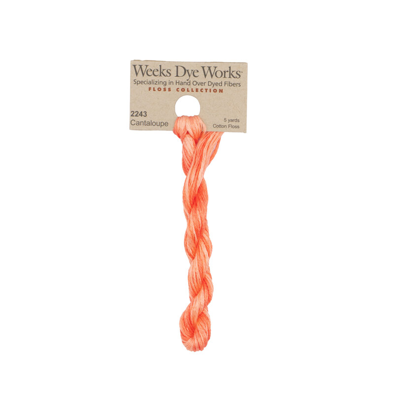 A skein of Salmon Orange embroidery floss, twisted and bundled, with a tan label featuring the brand name and color information.