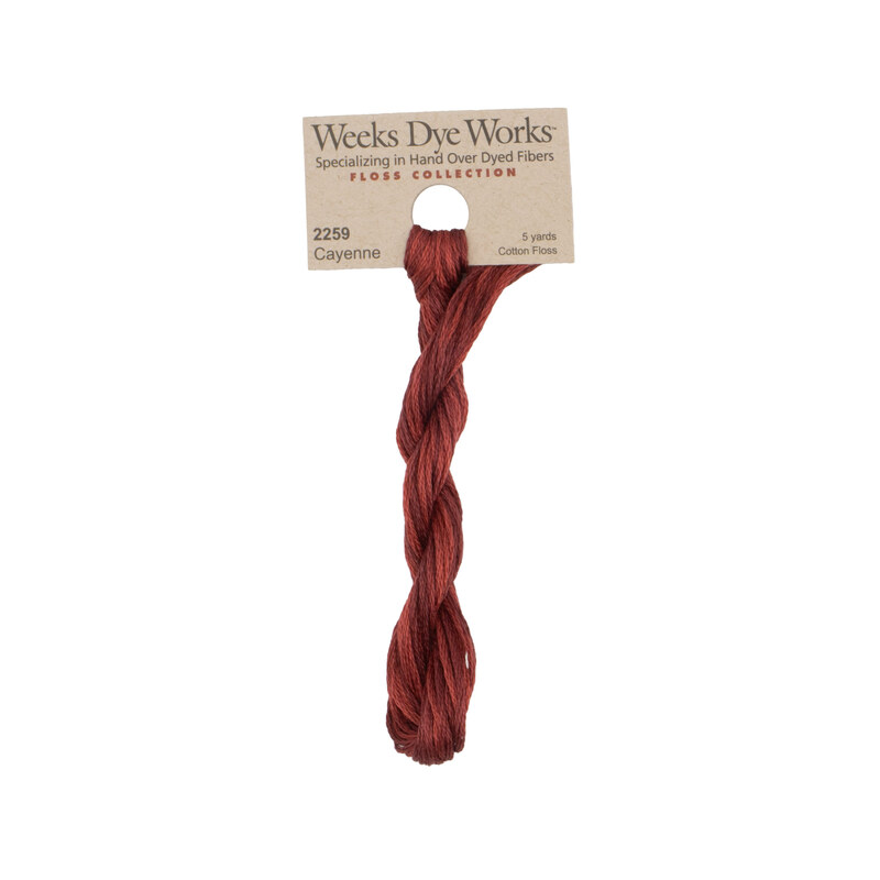 A skein of deep red embroidery floss, twisted and bundled, with a tan label featuring the brand name and color information.