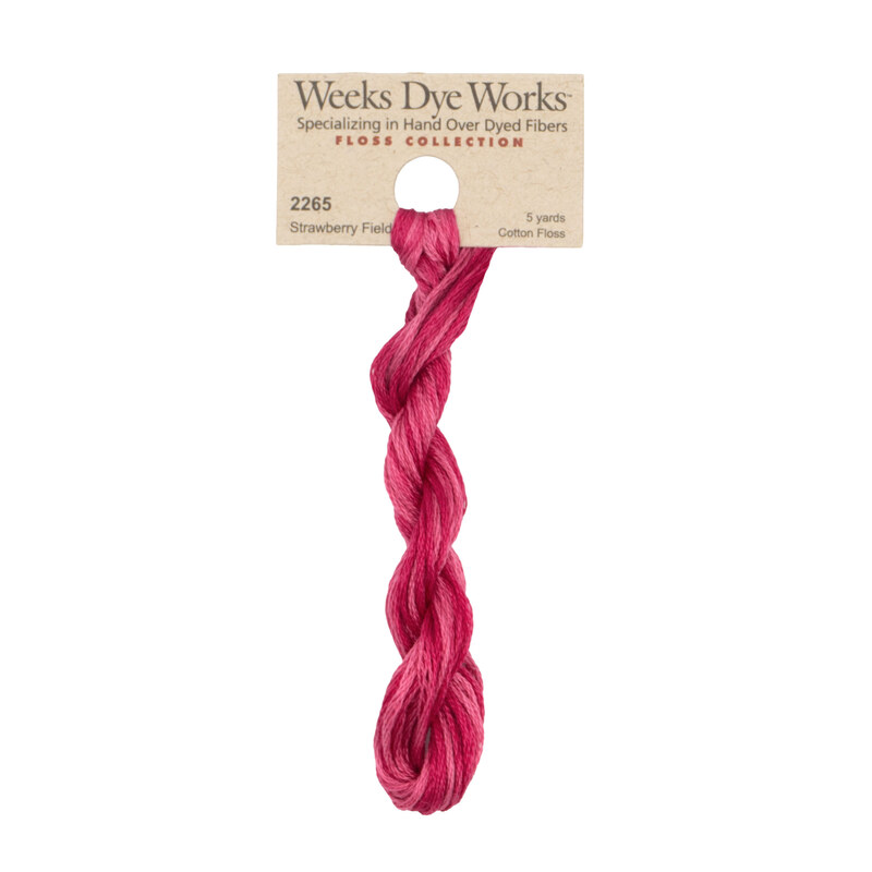 A skein of hot pink embroidery floss, twisted and bundled, with a tan label featuring the brand name and color information.