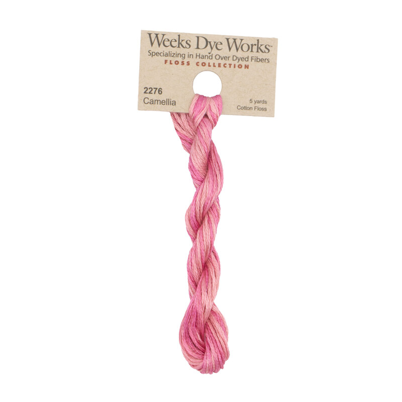 A skein of bubblegum pink embroidery floss, twisted and bundled, with a tan label featuring the brand name and color information.