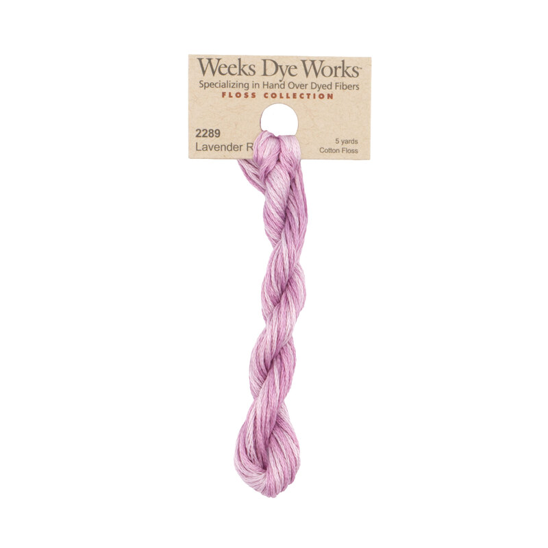 A skein of pale mauve embroidery floss, twisted and bundled, with a tan label featuring the brand name and color information.