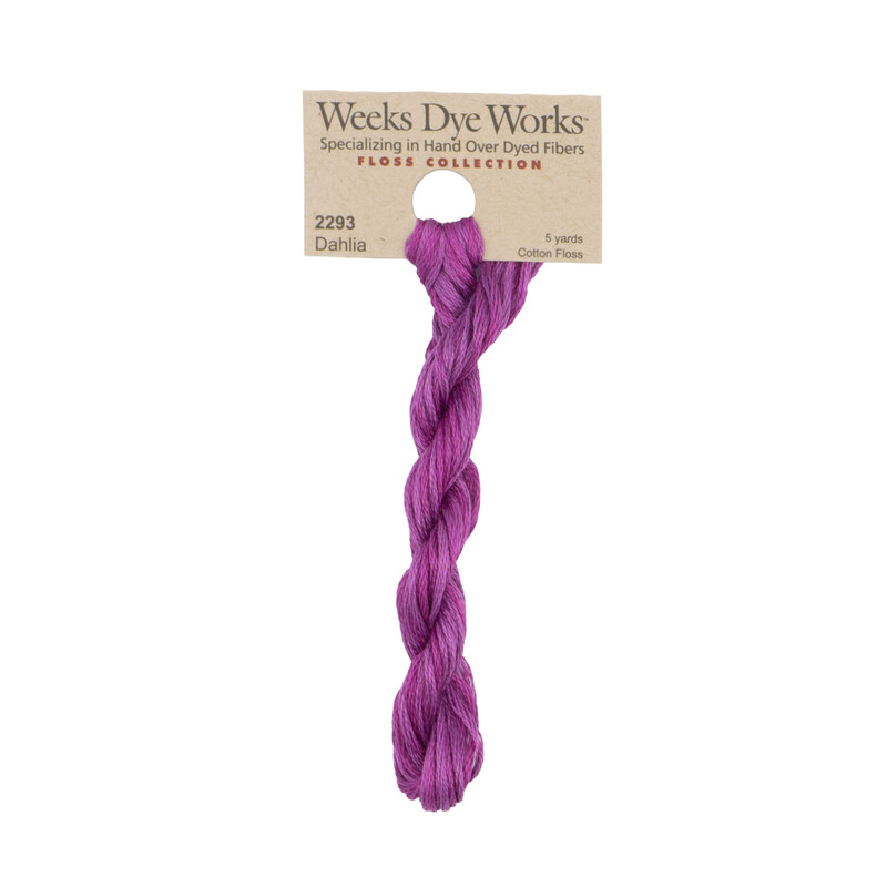 A skein of orchid purple embroidery floss, twisted and bundled, with a tan label featuring the brand name and color information.