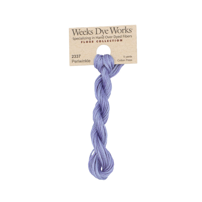 A skein of periwinkle embroidery floss, twisted and bundled, with a tan label featuring the brand name and color information.