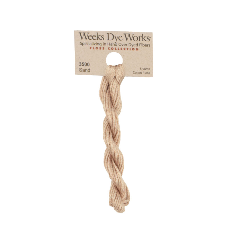 A skein of light palomino embroidery floss, twisted and bundled, with a tan label featuring the brand name and color information.