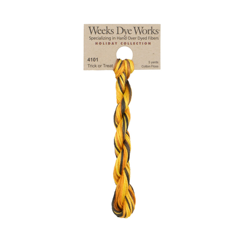 A skein of Variegated Yellow, Orange, and Brown embroidery floss, twisted and bundled, with a tan label featuring the brand name and color information.