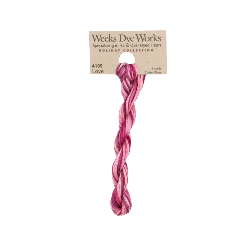 A skein of Variegated Magenta and Light Pink embroidery floss, twisted and bundled, with a tan label featuring the brand name and color information.